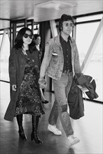 Former Beatle John Lennon with his wife Yoko Ono leaving Heathrow Airport for the Cannes Film festival where two of their films "The Fly" and "Apotheosis" are being shown. 14th May 1971.