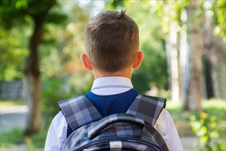 Boy is going to school with his school backpack. Schoolboy with backpack go to primary school. Back to school concept.