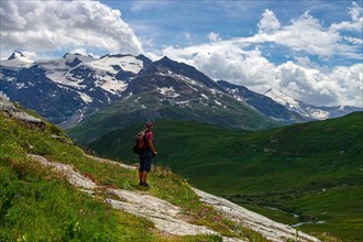 Female hiker with red rucksack in the La Lenta valley, under the Col d'Iseran, Vanoise National Park, France