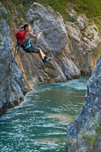 Woman crossing river on Tyrolean traverse  in the Verdon canyon