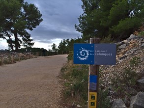 Blue signpost at the entrance of Calanques National Park (Parc National des Calanques) near Cassis at the French Riviera. Focus on sign.