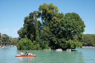 Tourists on Pedalo, Pedal Boat or Paddle Boat & Île des Cygnes, or Swan Island, Annecy Lake or Lac d'Annecy Haute-Savoie France