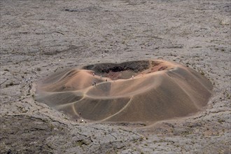 Hikers on an ancient crater of the Piton de la Fournaise volcano, Reunion Island, France. Seen from a distance, they look like ants.