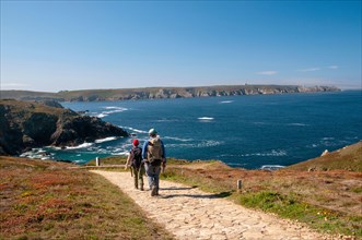 Hikers at Pointe du Van near Saint-They chapel, Trepasses bay and Iroise sea, Cleden-Cap-Sizun, Finistere (29), Brittany, France
