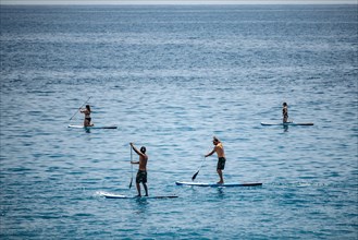 Nice, France - May 25, 2024: People paddling in the Mediterranean Sea near Nice