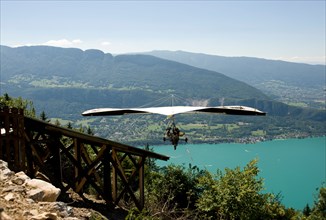 hang glider taking off from a ramp at the col de la forclaz above lake annecy haute savoie france