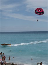 Paragliding by Nice beach, South of France, Mediterranean.  Boat, Parachute, Sun, tourism.