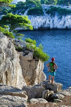 female wanderer looking at the rocky coast of Calanques, France, Provence, Calanques National Park, Marseille Cassis La Ciotat