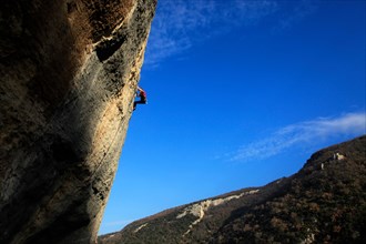 A climber scales cliffs at Buoux, Provence, France, Europe