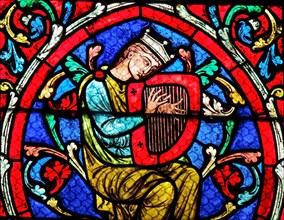 Stained glass window in the Notre Dame Cathedral in Paris, depicting King David playing on his Harp.