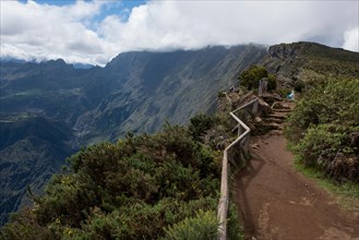 French Overseas Territory, Reunion Island. Scenic overlook into the Cirque of Mafate volcanic caldera, 2090 meters high. Tourists on the rim overlook
