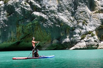 Mother and son paddling on SUP on turquoise water of Gorge du Verdon Provence France