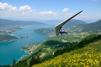 2014-06-25 Annecy, France. Hang glider pilot do aerobatic maneuvers over lake Annecy. Popular place for doing extreme sports.