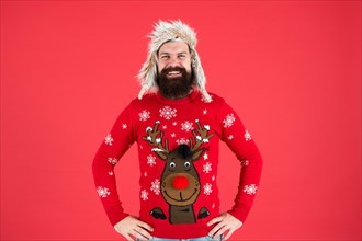 Join holiday party craze and host Ugly Christmas Sweater Party. Sweater with deer. Hipster bearded man wear winter sweater and hat. Happy new year. Winter party outfit. Buy festive clothing.