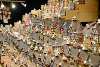 Souvenir at the Strasbourg Christmas Market, a stall display of little multicoloured Alsacian houses in a row, captured at angle,