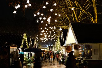 German Christmas market at night  with market stalls and illuminated stars