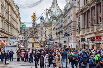 The famous Graben street with many tourists during the Christmas holidays,  the Plague column in the middle of the street, Vienna, Austria.