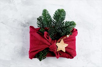 Zero waste, eco friendly concept. Furoshiki gifts present wrapping with linen fabric and fir tree branch. Top view, flat lay