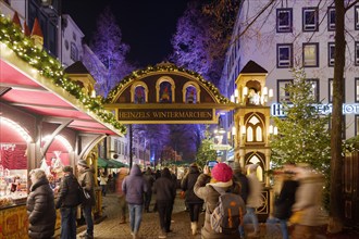 Night scenery, beautiful arched entrance of Weihnachtsmarkt, Christmas Market in Köln, at Alter Markt, famous marketplace nearby Cologne city hall.