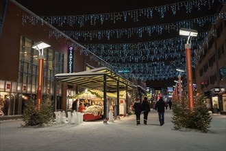 A street in Rovaniemi city with New Year and Christmas decorations, Finland, Lapland. Christmas market, blue New Year's illumination.