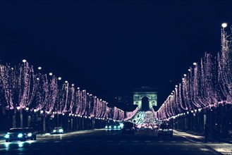 Arch of Triumph and Champs Elysees with Christmas festive illumination. Paris during winter holidays concept. Travel destination background. Vintage t