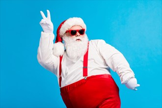 Photo of cool funky overweight santa claus with big belly beard dance x-mas christmas discotheque wear headwear suspenders overalls sunglass isolated