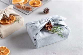 Furoshiki gifts. Christmas presents wrapped in fabric and decorated with natural decor.