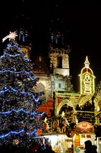 Christmas Prague at night. Glowing Christmas tree and beautiful decoration in front of Church of Our Lady before Týn on Old town square