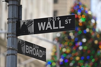 Wall Street and Broad St. signs are seen as New York Stock Exchange building decorated for Christmas at the Financial District on December 1, 2022 in