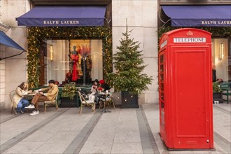 England, London, Piccadilly, New Bond Street, Exterior View of Ralph Lauren Store with Christmas Decorations and Traditional Red Telephone Box