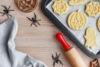 Preparation of festive cookies for baking in the oven. Ready-to-bake Halloween cookies shaped like pumpkins and ghosts