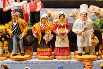 Display of Santon figurines with focus on cooking workers for sale in a market booth  at the Strasbourg Christmas Market