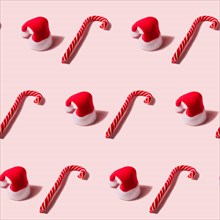 Trendy Christmas seamless texture with Santa Claus hat and candy cane. Modern christmas design