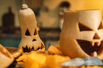 Close up of carved pumpkins, horizontal photo, out of focus background, Halloween preparation crafts, party celebration and tradition.