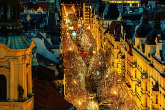 View from above of the evening street illuminated for Christmas holidays among typical historic buildings in Prague, Czechia.