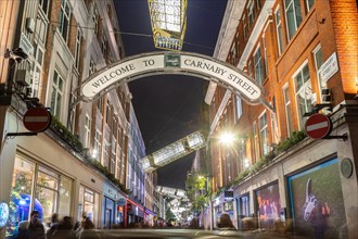 LONDON, UK - 9TH NOV 2024: A view along Carnaby Street at Christmas showing the decorations and lights. People can be seen below the decorations along