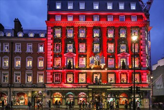 London, UK. 18th Nov, 2024. The annual 'advent calendar' facade decorations and 2024 display glows in festive red on the Fortnum and Mason building in Piccadilly. Christmas Lights, baubles and elabora...