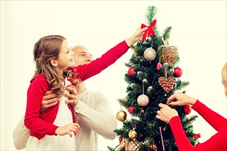 smiling family decorating christmas tree at home