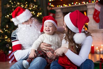 Happy family with child son having a fun near Christmas tree and fireplace  in living room