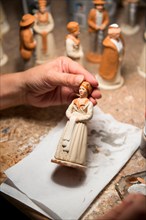 An artisan paints ceramic figurines at Atelier Arterra, a workshop and store located in the Panier neighborhood of Marseille.