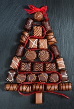 Chocolate  pralines Christmas tree on stone black table