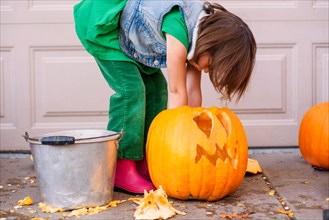 Girl carving a Halloween pumpkin