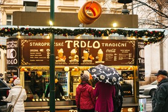 Prague on Christmas Day. Tourists in buy Trdlo in the stall - national food of the Czechs