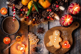 Christmas homemade gingerbread cookies, hot chocolate and candles on wooden table