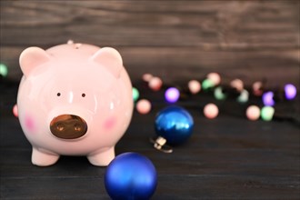 Piggy bank and Christmas decorations on table