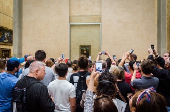 Crowd of people taking pictures of Mona Lisa by Leonardo da Vinci at The Louvre, Paris, France