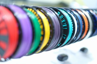 Closeup of spools with multi-colored plastic wires for 3D printers