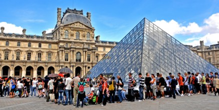 Tourists queue before the Pyranid of Louvre museum, Paris, France