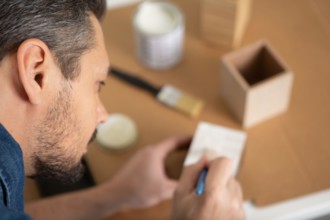 man painting handmade pottery at ceramic workshop art concept