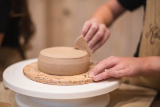 Woman hands, pottery studio and painting cup in workshop for sculpture, creative manufacturing or design. Painter, ceramics product and brush process,